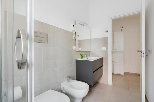 a white bathroom with a toilet and a sink at Scirocco Guest House in Brindisi