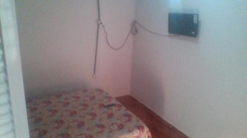 a small room with a bed and a wall at POUSADA Br381 in Extrema