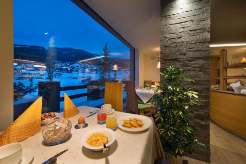 a table with plates of food on it in a restaurant at Hotel Roberta Alpine Adults only in Livigno