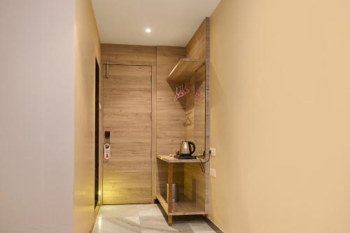 a hallway with a door and a table in a room at Hotel Hrushikesh in Shirdi