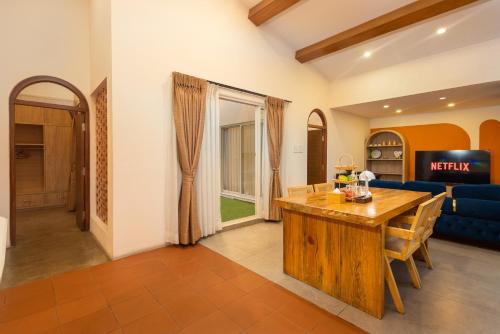 a living room with a wooden table and a blue couch at Sam's Apartment in Pātan