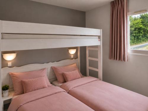 a bedroom with two beds with pink pillows at La TERRASSE in Salavas