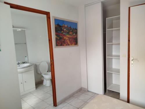 a bathroom with a toilet and a painting on the wall at La TERRASSE in Salavas
