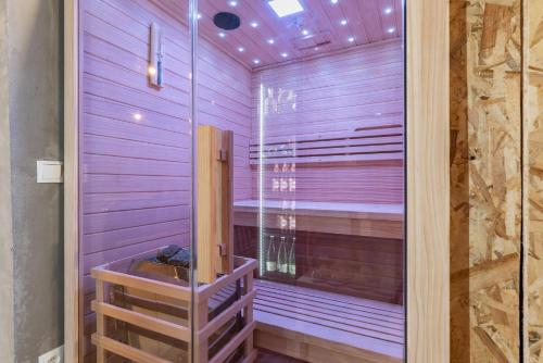 a sauna with purple walls and a glass door at Villa Omaha in Vekići