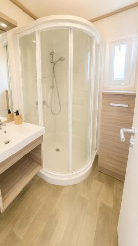a white bathroom with a shower and a sink at Au Paradis de Peggy - Bungalow 5 pers - Village de la Pointe Faula in Le Vauclin
