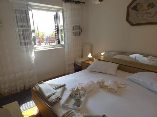 a bedroom with a bed with towels and a window at Casa Maja in Karlobag