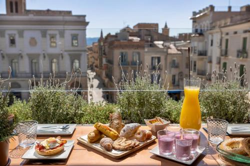 ein Tisch mit Brot und Gebäck auf einem Balkon in der Unterkunft Cal Roure Boutique Hotel in Igualada