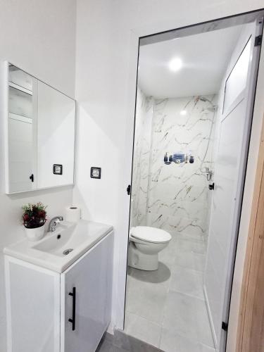 a white bathroom with a toilet and a sink at S1 Modern & Relax in Agadir