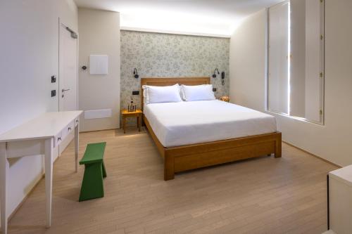 a bedroom with a bed and a table and a desk at Hotel de La Ville - Self Check-In in Fidenza