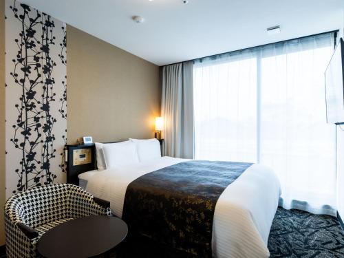 a hotel room with a bed and a table and a window at APA Hotel Kyoto Gion Excellent in Kyoto