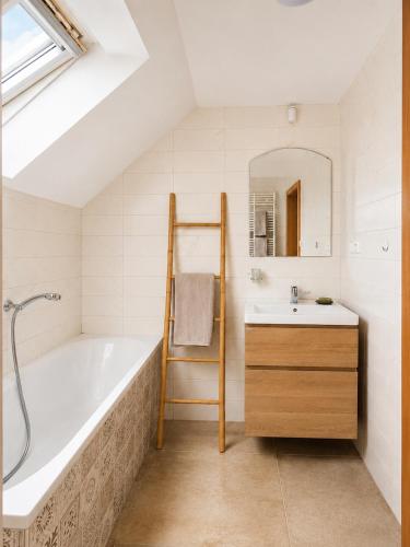 a bathroom with a bath tub and a sink at Ayni Apartment Semily in Bohemian Paradise in Semily