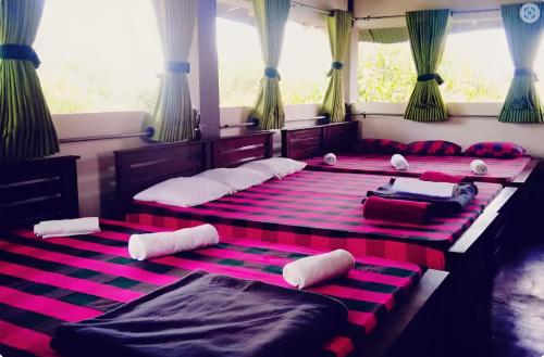 two beds in a room with pink and black stripes at The Green Heritance in Habarana