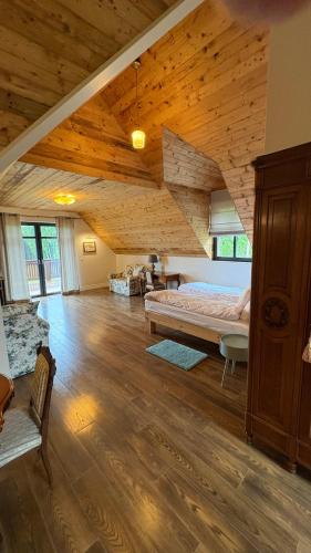 a bedroom with a large bed in a room with wooden ceilings at Warmińska Sielanka in Blanki