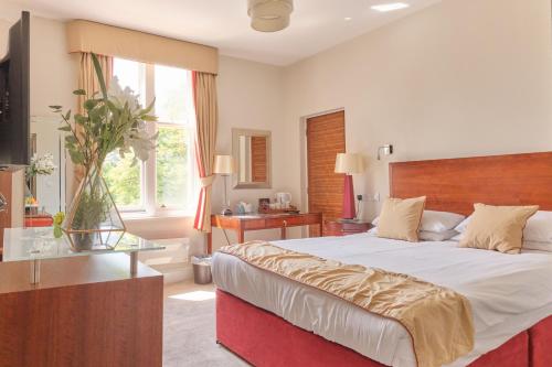 a bedroom with a large bed and a large window at Kings Park Hotel in Retford