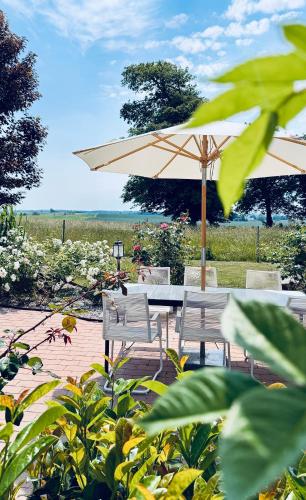 a table and two chairs and an umbrella at Villa Verde Österlen in Glemminge