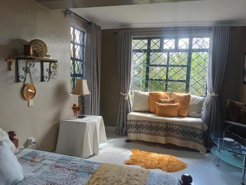 a bedroom with a bed and a window with pillows at Sereni stays in Nakuru