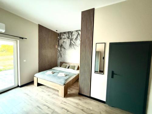 a bedroom with a bed and a large window at Pełnia Mazur in Pasym