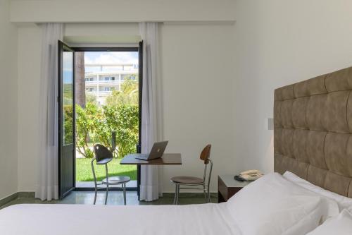 ein Schlafzimmer mit Bett und Schreibtisch mit Laptop in der Unterkunft Rada Siri in Montepaone