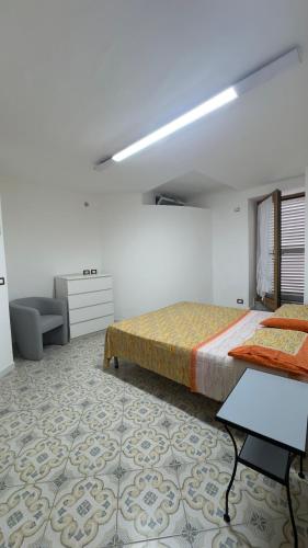 a white room with a bed and a chair and a table at case vacanza hoya in Lacco Ameno