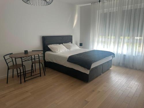 a bedroom with a bed and a table with a tableablish at Soliq Stay App in Tuzla