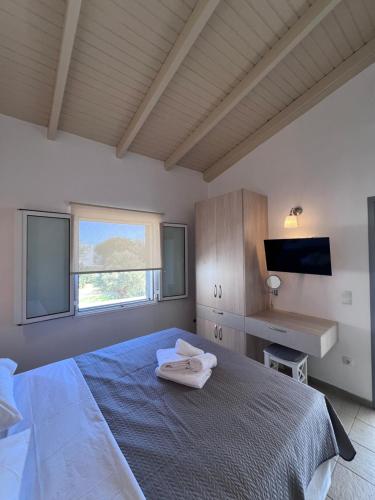 a bedroom with a bed with two towels on it at Kea Harbor 2 in Korissia