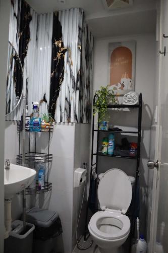 a bathroom with a white toilet and a sink at Yangʻs HoMeey Place in Bankal
