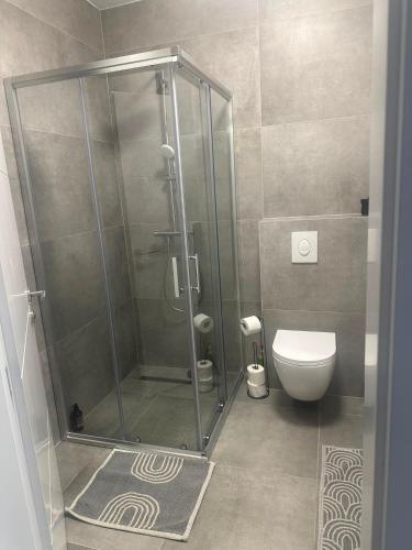 a bathroom with a shower and a toilet at Soliq Stay App in Tuzla