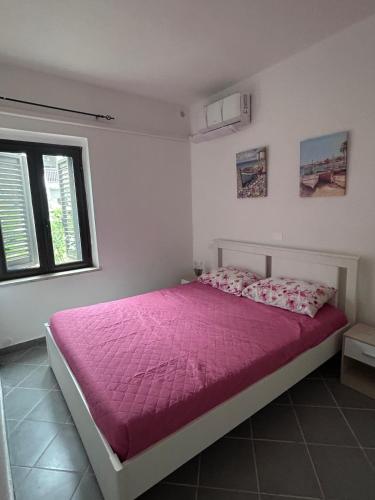 a bedroom with a bed with a pink comforter at Villa del Limone in Sellia Marina