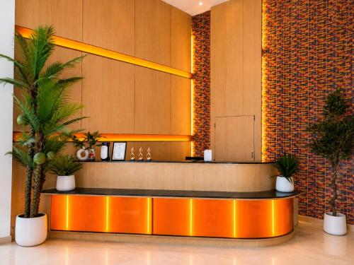a lobby with a reception desk with two palm trees at Dee Residence Phuket in Patong Beach