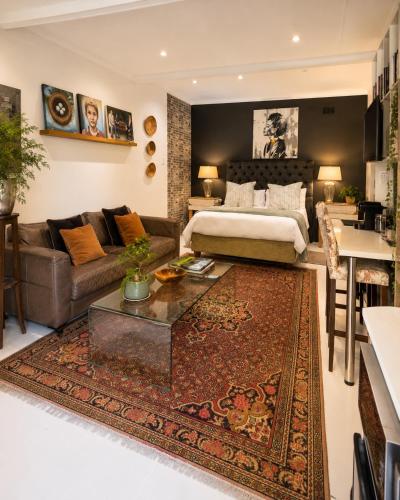 a bedroom with a bed and a couch and a table at Art-Inspired Bedroom Close to CBD in Mossel Bay