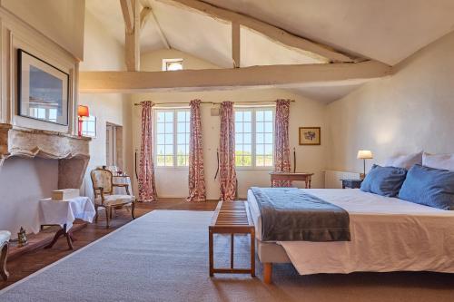 a bedroom with a large bed and a fireplace at Maison d'hôtes de charme Le Clos de la Cathédrale en Sud Gironde in Bazas