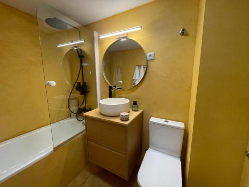 a bathroom with a toilet and a sink and a mirror at El rincón de la Rapeda in Villanúa