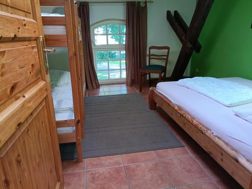 a bedroom with a bed and a window at Ferien am Schloss - Wohnung 5 "der Hahn", Ferienwohnung am Badesee in Behren-Lübchin