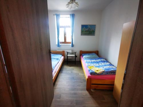 a small room with two beds and a window at Farma Dolní Dvořiště in Dolní Dvořiště
