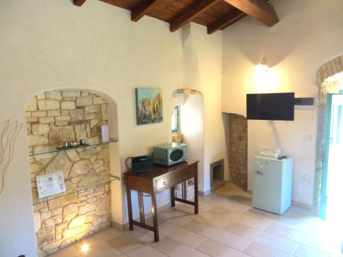 a room with a refrigerator and a table with a microwave at Case Vacanza Al Borgo Antico in Vico del Gargano