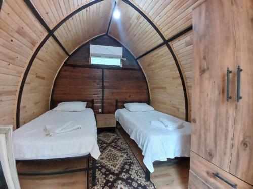 two beds in a room with an arched ceiling at Kalinka pansiyon in Cıralı