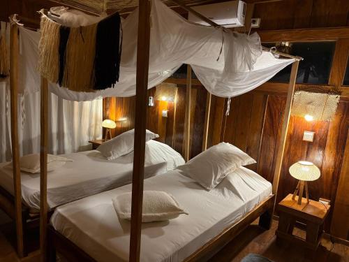 a bedroom with two bunk beds with white sheets at Anchaca Sul in Bubaque
