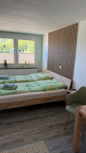 a bedroom with a large bed and a chair at Ferienwohnung in Zirchow