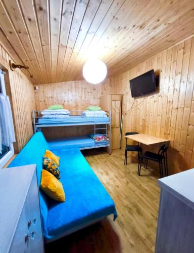 a room with a blue couch in a room with a table at OliMarii domki nad jeziorem Jezioro Złotnickie Karłowice 19 a,b in Karłowice
