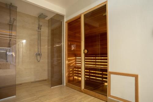 ein Badezimmer mit ebenerdiger Dusche und Duschkabine aus Glas in der Unterkunft Hotel Enigma in Žabljak