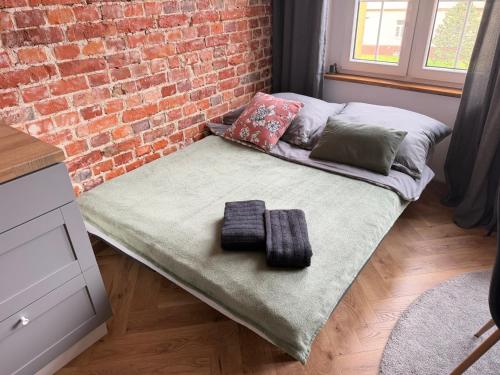 a bed in a room next to a brick wall at UNESCO Loft House 24h Tarnowskie Góry Rynek 5 min in Tarnowskie Góry