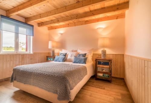 
a bedroom with a large bed and a large window at Monte do Cardal in Odeceixe
