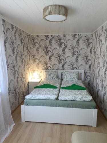 a bedroom with a bed and a wall with wallpaper at Viscosa Sadama tee külaliskorter in Kõrgessaare