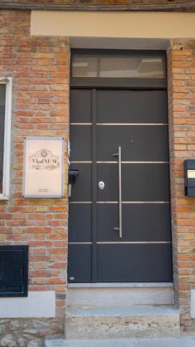a black garage door on a brick building at VIBINUM Bed & Breakfast in Bovino
