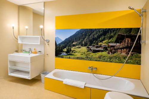 a bathroom with a tub with a picture of a mountain at Sun Matrei Apartments in Matrei in Osttirol