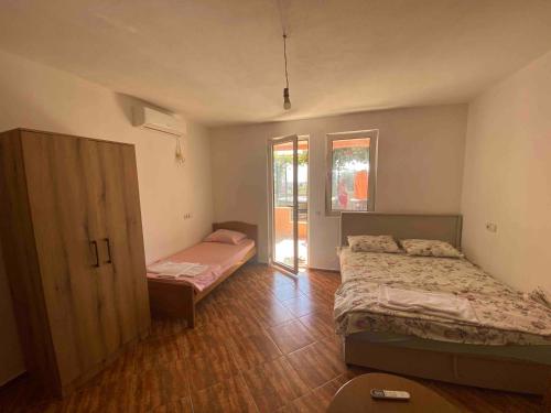 a bedroom with two beds and a sliding glass door at Apartmani Adelisa in Šušanj