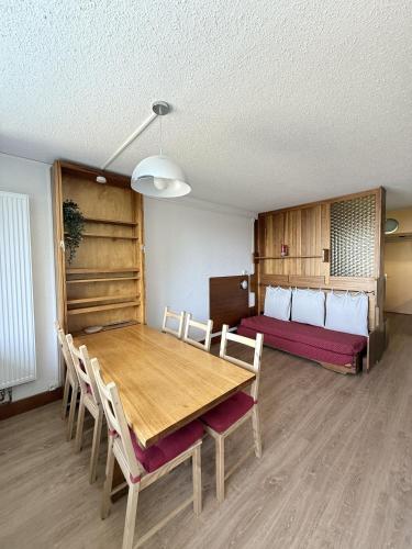 a dining room with a table and chairs and a bed at Stud 4 Pers Roche Béranger piscine in Chamrousse