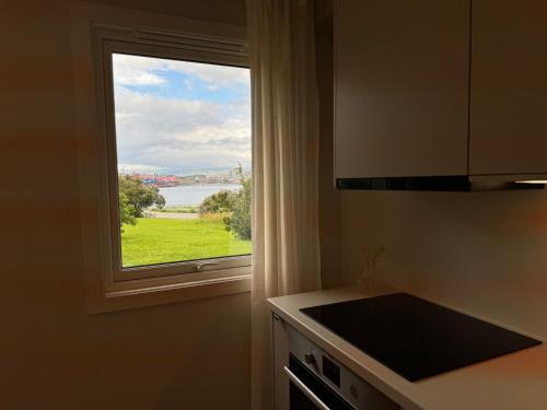 a kitchen with a window with a view of the water at Parkside apartment in Narvik