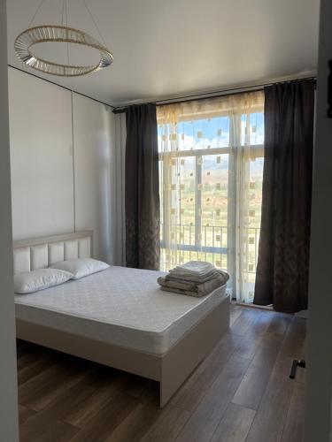 a bedroom with a bed and a large window at Lake in Bosteri