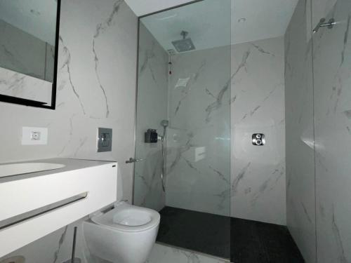 a bathroom with a toilet and a glass shower at Nordis 22 Deluxe Room Mamaia Nord in Mamaia Sat/Năvodari